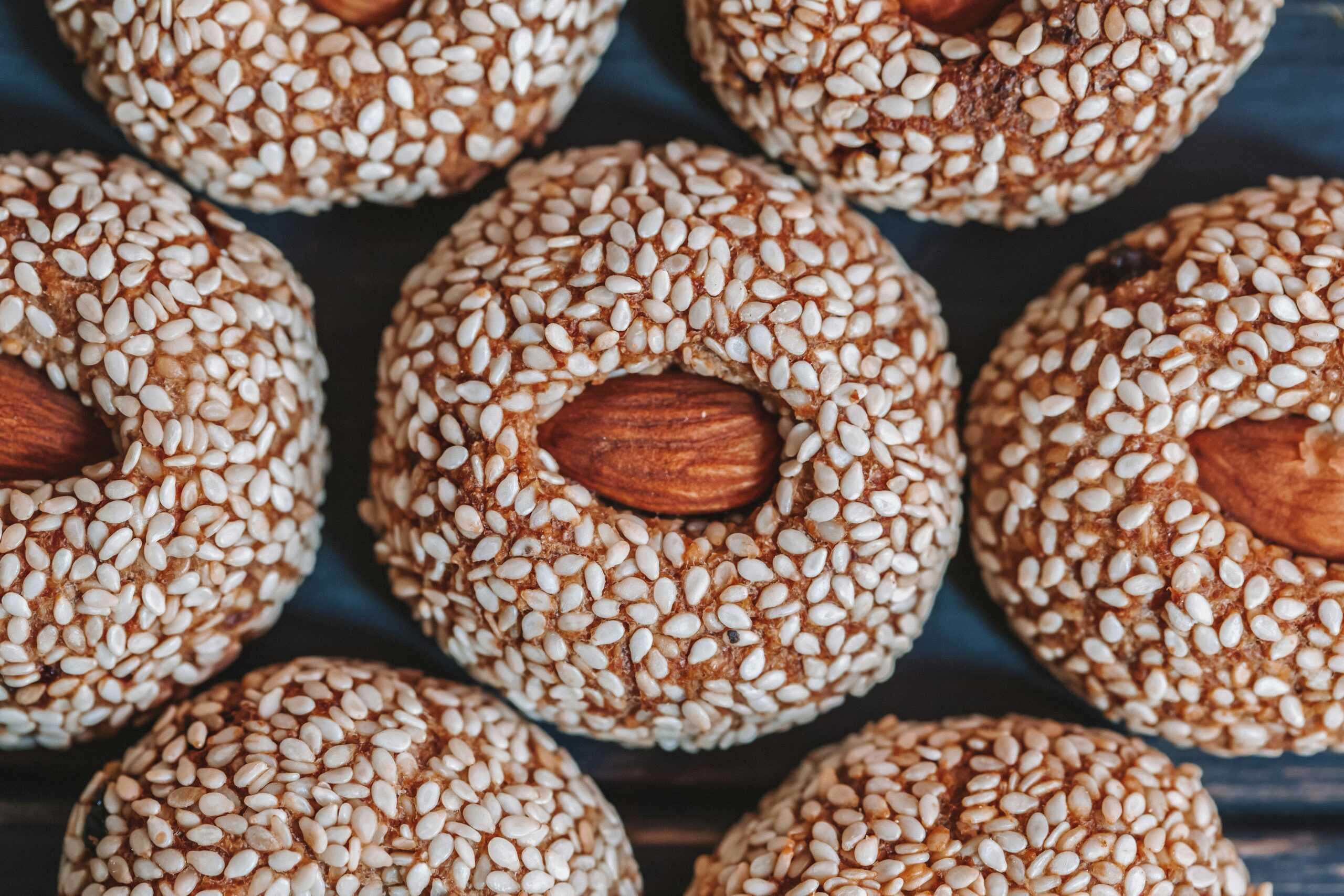 Top view of background representing tasty biscuits with whole almonds in center and sesame seeds on top